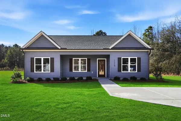 a front view of a house with a yard and potted plants