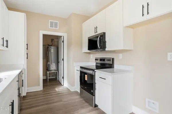 a kitchen with stainless steel appliances a stove microwave and sink
