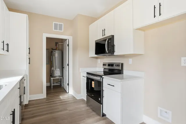 a kitchen with stainless steel appliances a stove microwave and sink