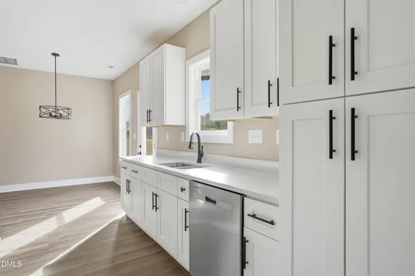 a kitchen with white cabinets and sink