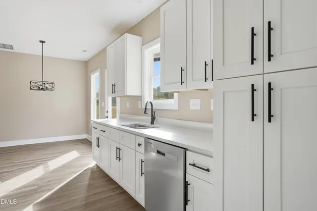 a kitchen with white cabinets and sink