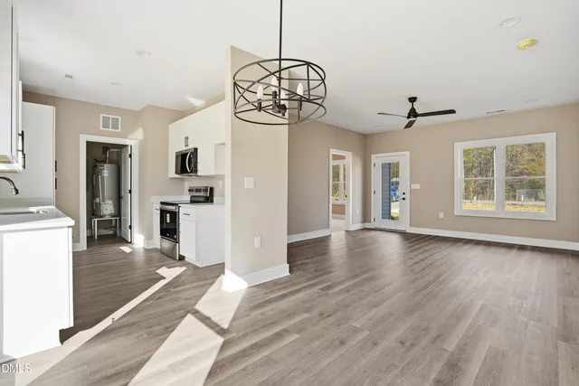 a view of a room with wooden floor fireplace and windows