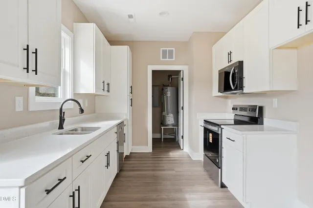 a kitchen with white cabinets stainless steel appliances and sink