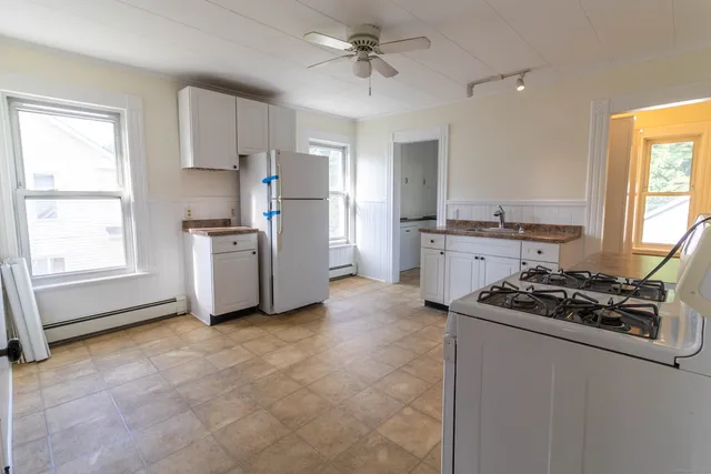 a kitchen with cabinets appliances and a window