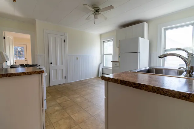 a kitchen with granite countertop a sink and a stove top oven