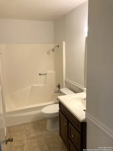 a bathroom with a granite countertop sink a toilet and bathtub