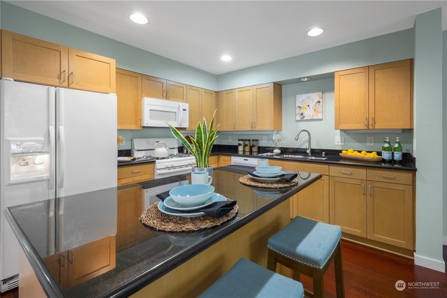 a kitchen with granite countertop a table and chairs in it