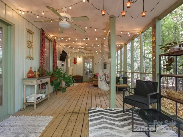 a living room with furniture a flat screen tv and floor to ceiling window