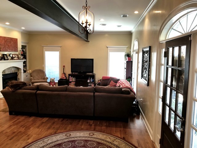 415 Wheeler Road Gray, GA 31032 - Photo 5 of 25 a living room with furniture a flat screen tv and a chandelier