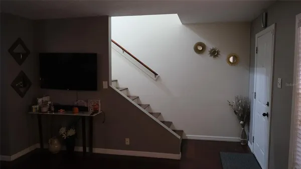 a view of a hallway with wooden floor and living room