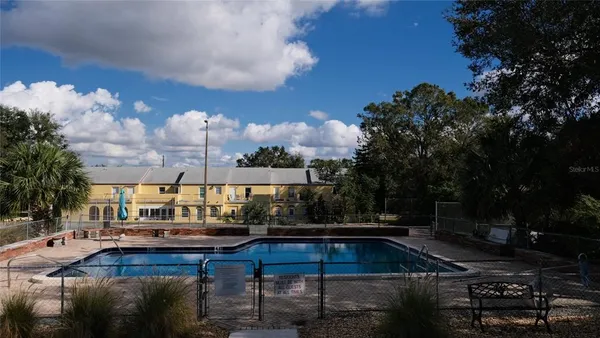 a swimming pool view with sitting space and garden space