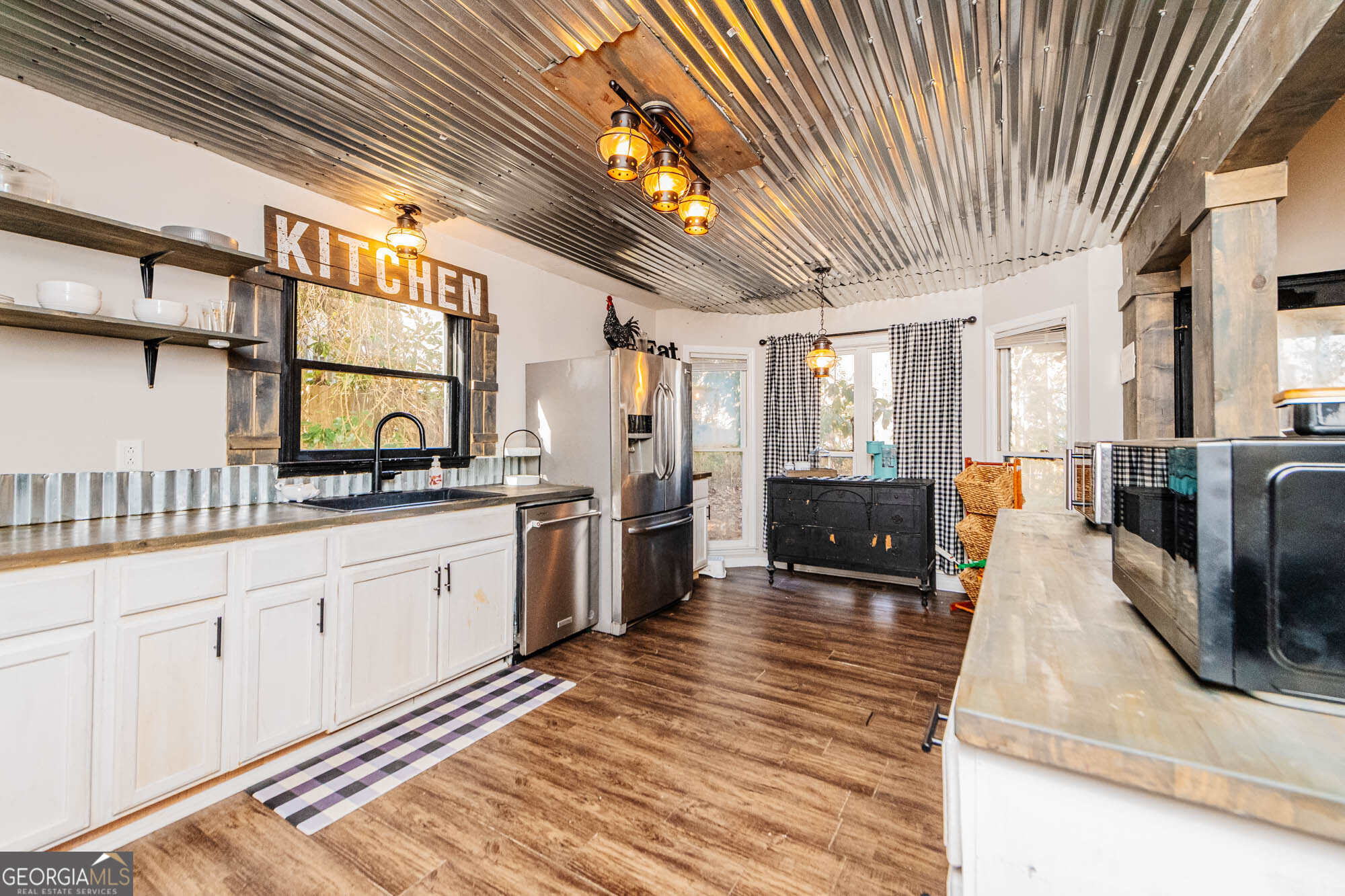 5341 Northside Drive Macon, GA 31210 - Photo 11 of 43 a large white kitchen with wooden floor and chandelier