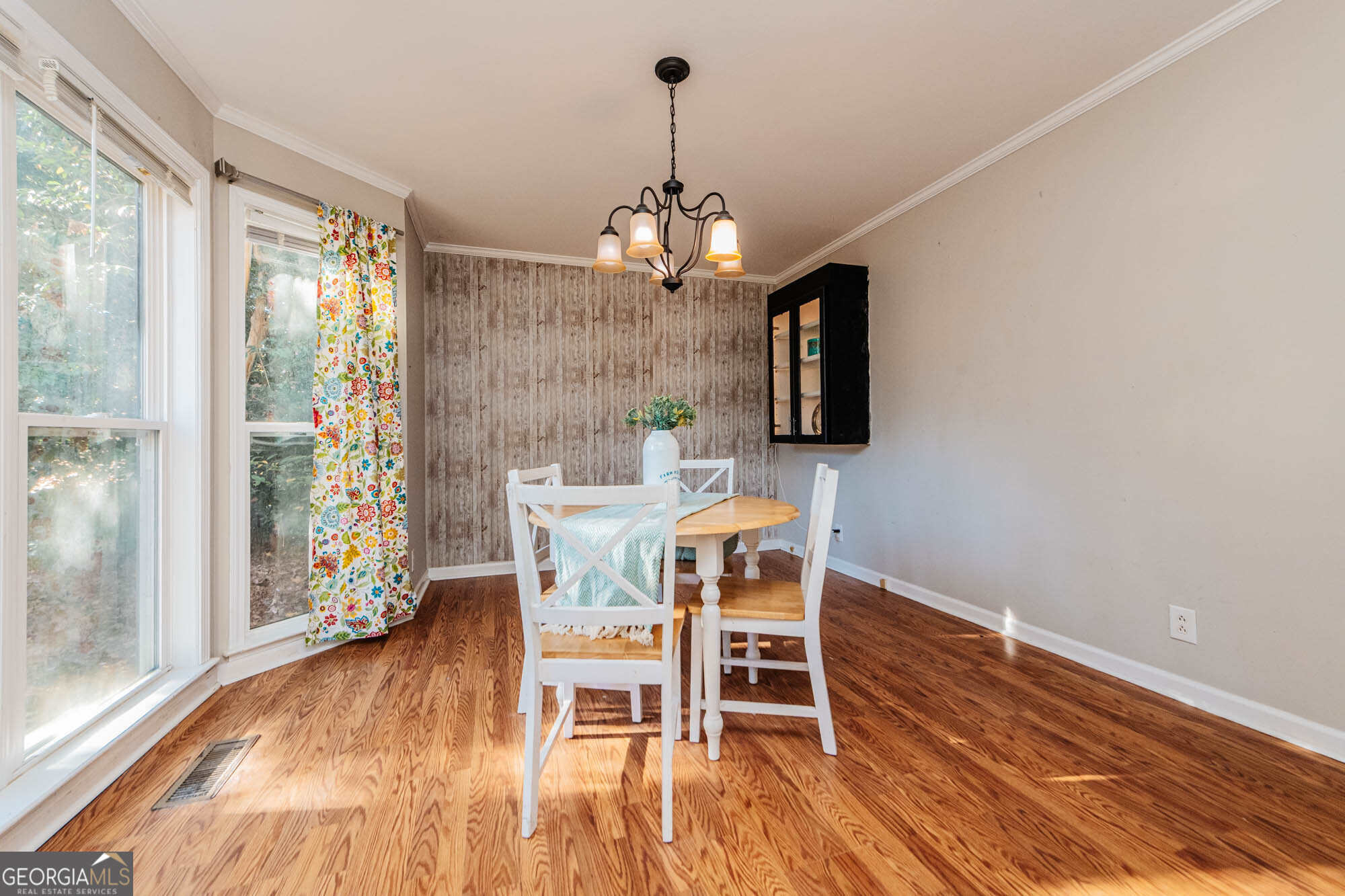 5341 Northside Drive Macon, GA 31210 - Photo 4 of 43 a dining room with wooden floor a chandelier a glass table and chairs