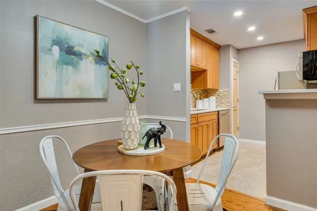 a view of a dining room with furniture one side kitchen view and wooden floor