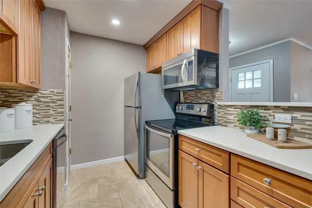 a kitchen with stainless steel appliances granite countertop a refrigerator a stove and a sink with cabinets