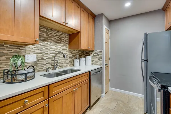 a kitchen with stainless steel appliances granite countertop a sink and a refrigerator