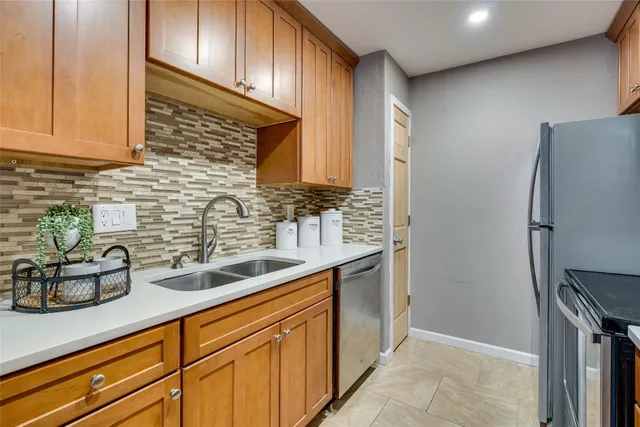 a kitchen with stainless steel appliances granite countertop a sink and a refrigerator