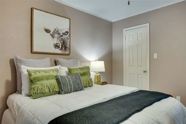 a bedroom with a bed and painting on the wall