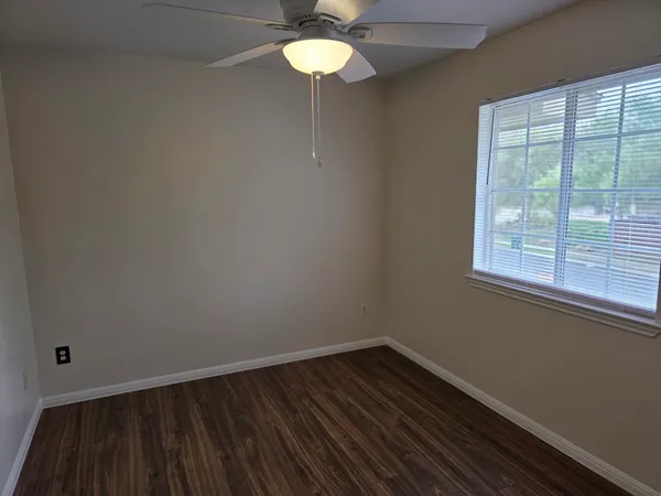 a view of wooden floor and a chandelier fan in a room