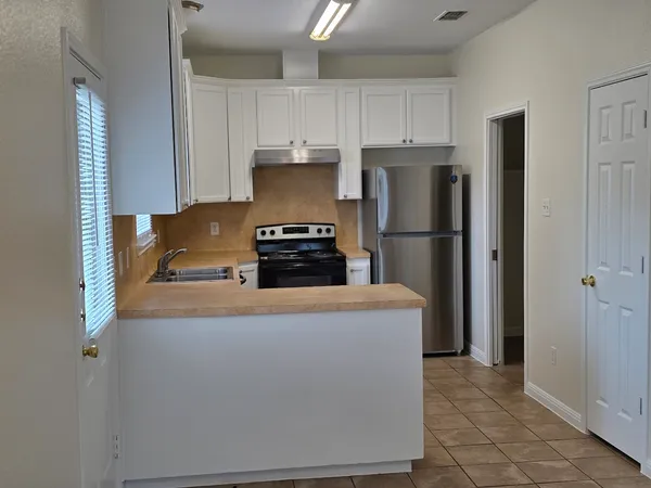 a kitchen with stainless steel appliances granite countertop a refrigerator a stove a sink and a refrigerator