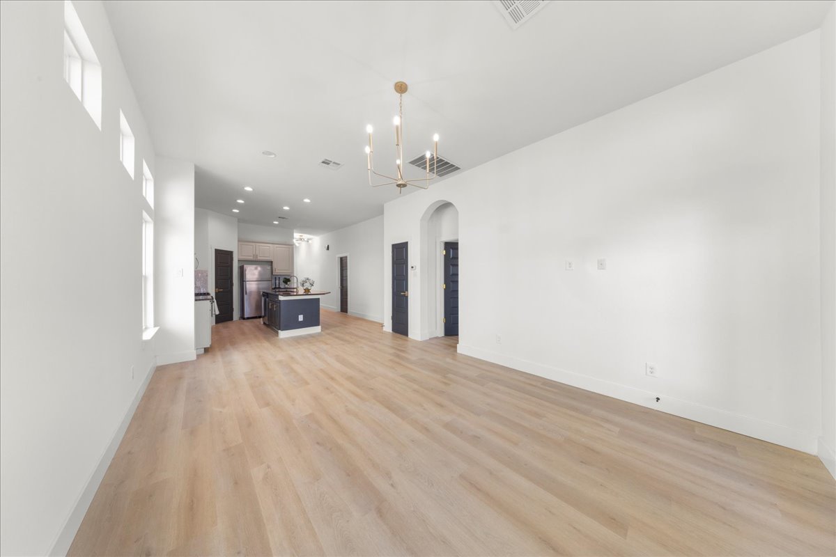 2408 Vintage Stave Road, Unit 101 Austin, TX 78748 - Photo 14 of 32 Unfurnished living room featuring arched walkways, light wood finished floors, recessed lighting, and a chandelier