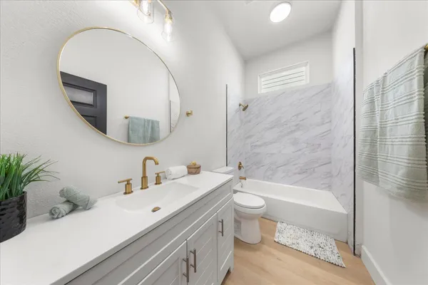 a bathroom with a sink a toilet and a mirror