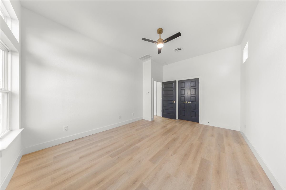 2408 Vintage Stave Road, Unit 101 Austin, TX 78748 - Photo 20 of 32 Unfurnished bedroom with multiple windows, ceiling fan, and light wood-type flooring