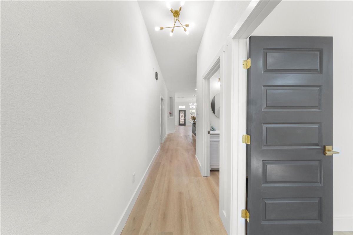 2408 Vintage Stave Road, Unit 101 Austin, TX 78748 - Photo 3 of 32 Hall with light wood-style flooring and a chandelier