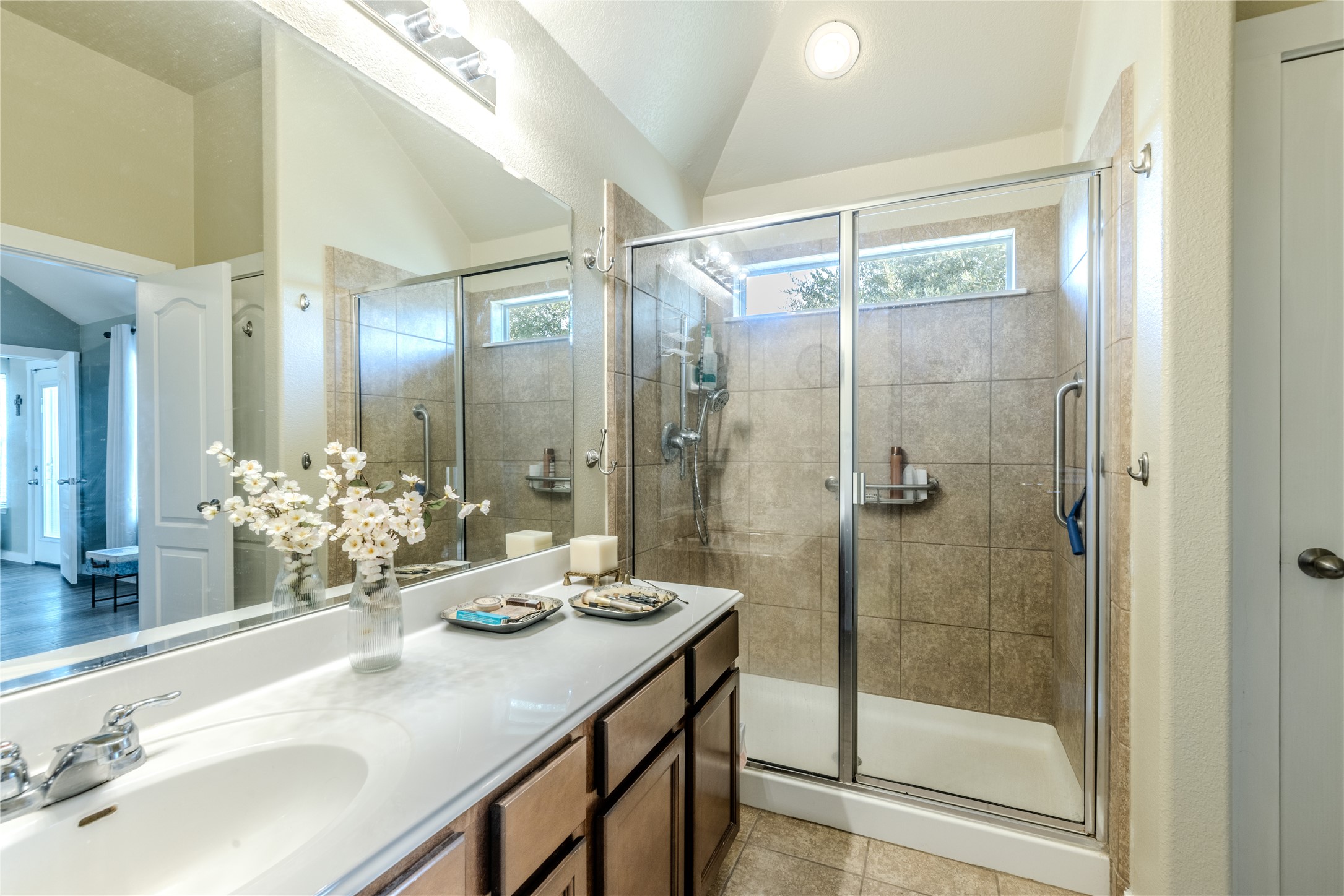 1089 Hot Spring Valley Buda, TX 78610 - Photo 12 of 26 A spacious vanity and a walk-in shower with tiled walls define this elegant space.