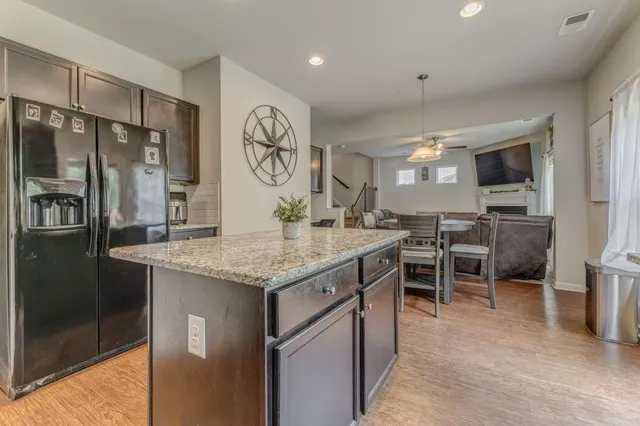 a kitchen with stainless steel appliances granite countertop a sink a stove and a refrigerator