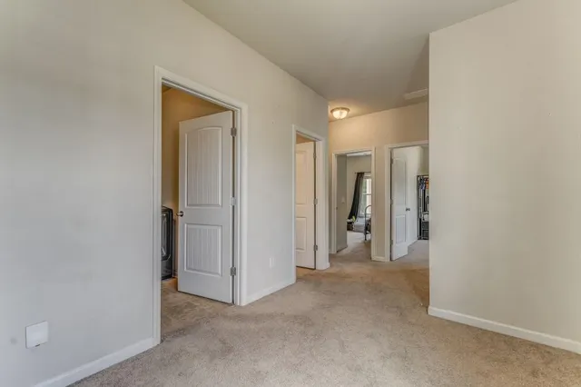 a view of hallway with closet and wooden floor