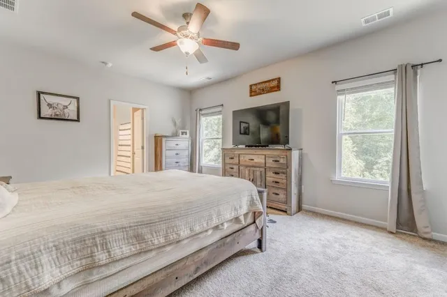 a spacious bedroom with a bed and a flat screen tv