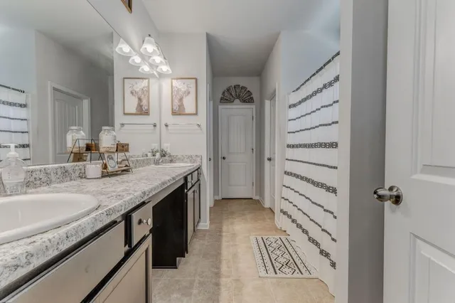 a bathroom with a granite countertop sink a mirror and a shower