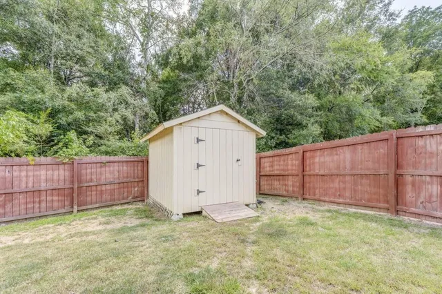 a view of backyard of house with wooden fence