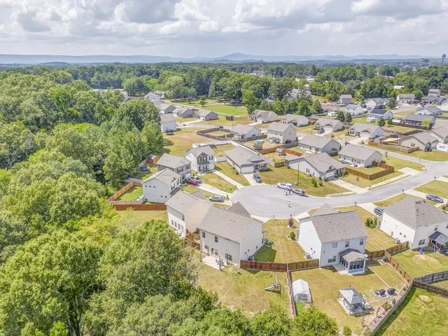 an aerial view of residential house with outdoor space and trees all around