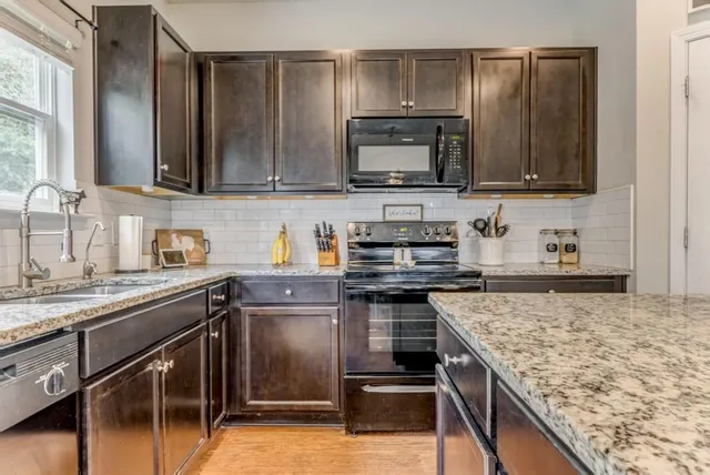 a kitchen with stainless steel appliances granite countertop a sink stove and microwave