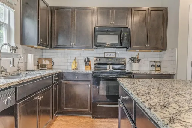 a kitchen with stainless steel appliances granite countertop a sink stove and microwave