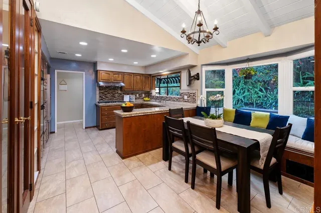 a view of a dining room with furniture a chandelier and large window