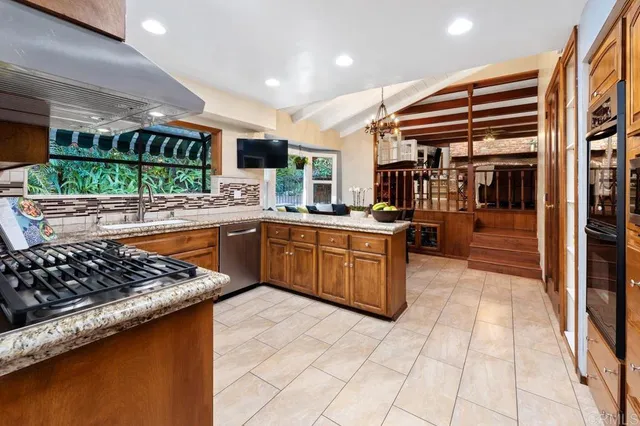 a kitchen with stainless steel appliances granite countertop a stove a sink and a microwave