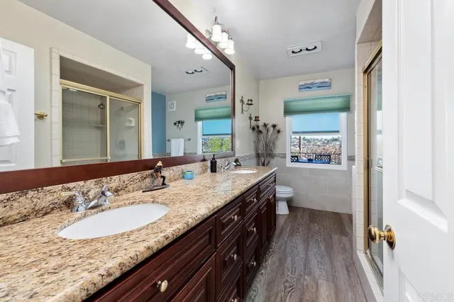 a spacious bathroom with a granite countertop sink a mirror and a shower