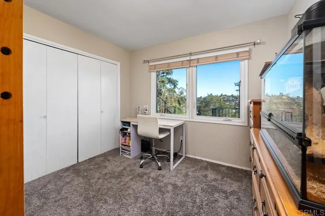 a view of a workspace with furniture and a window