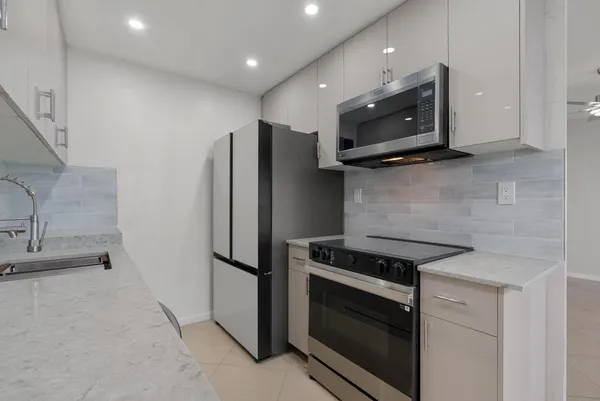 a kitchen with stainless steel appliances granite countertop a stove microwave and refrigerator