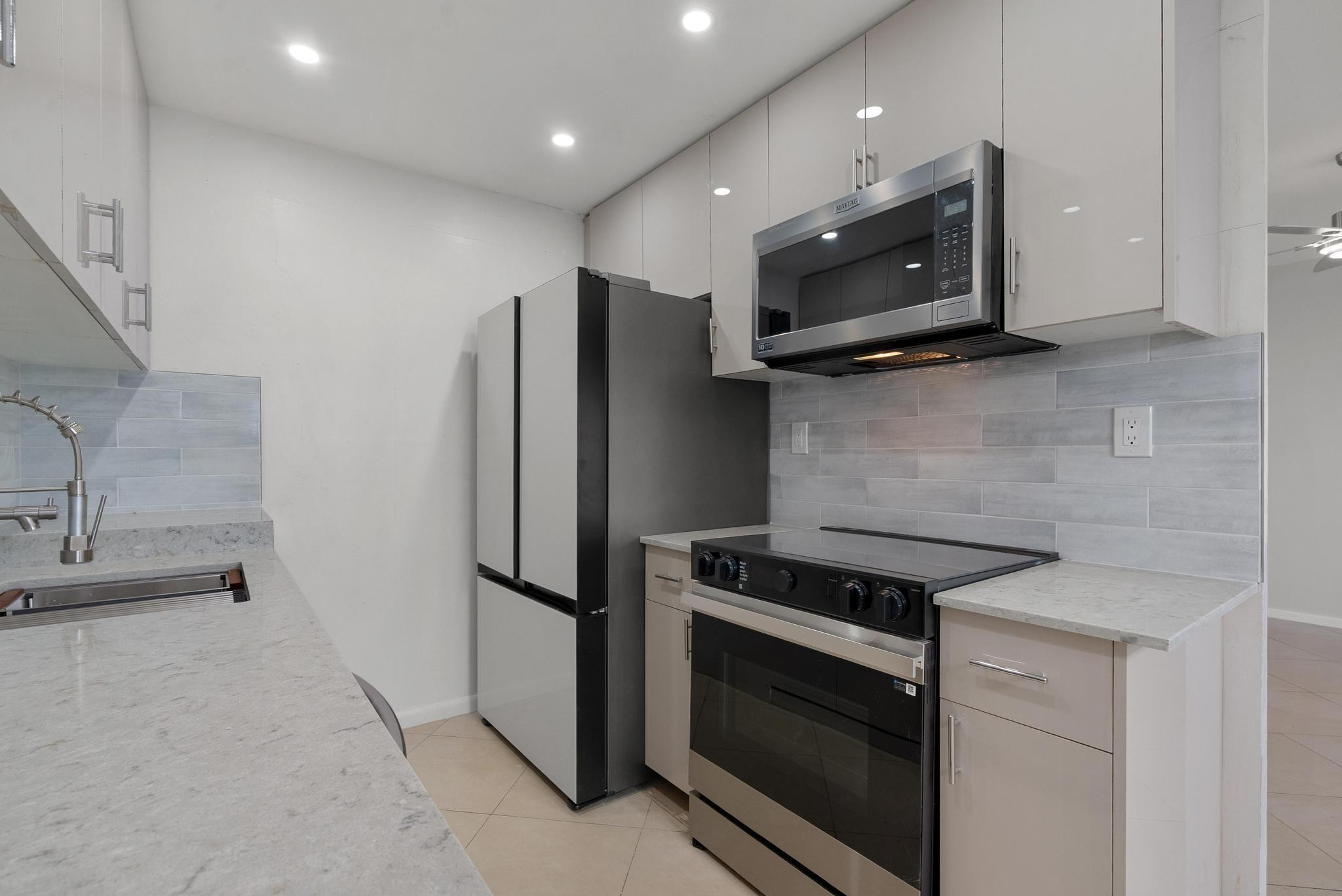 a kitchen with stainless steel appliances granite countertop a stove microwave and refrigerator