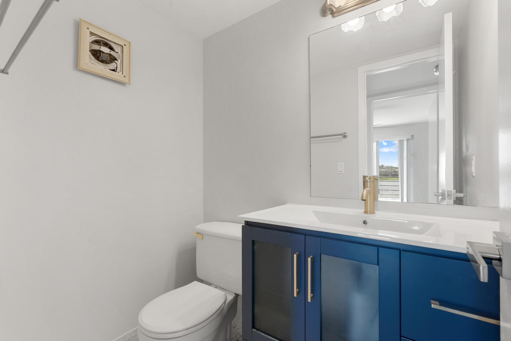 3038 Cornwall East, Unit 3038 Boca Raton, FL 33434 - Photo 18 of 32 a bathroom with a sink a toilet and mirror