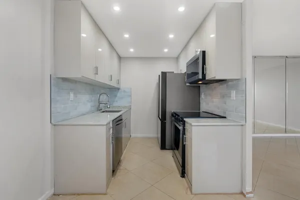 a kitchen with a refrigerator sink stove and cabinets