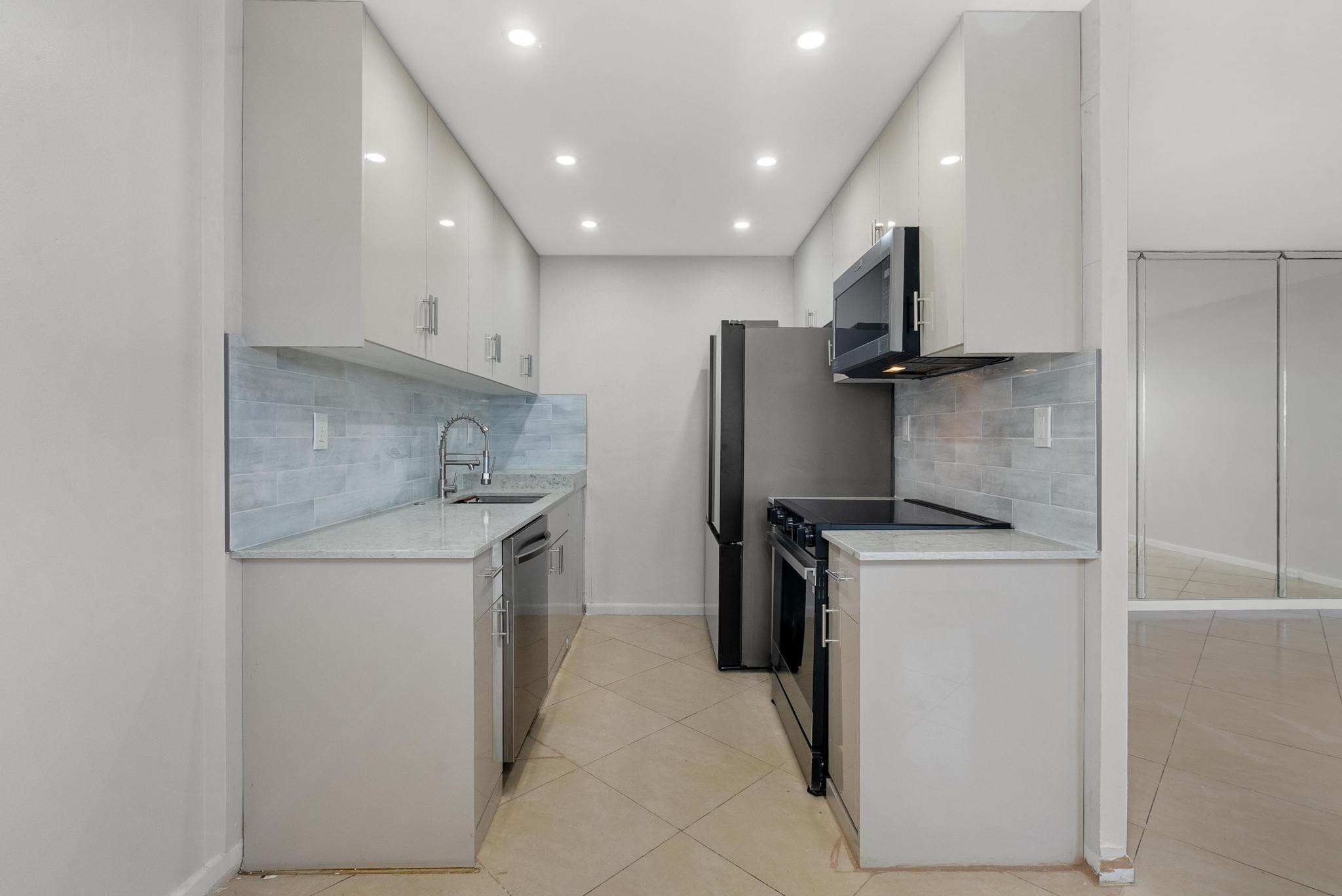 3038 Cornwall East, Unit 3038 Boca Raton, FL 33434 - Photo 3 of 32 a kitchen with a refrigerator sink stove and cabinets