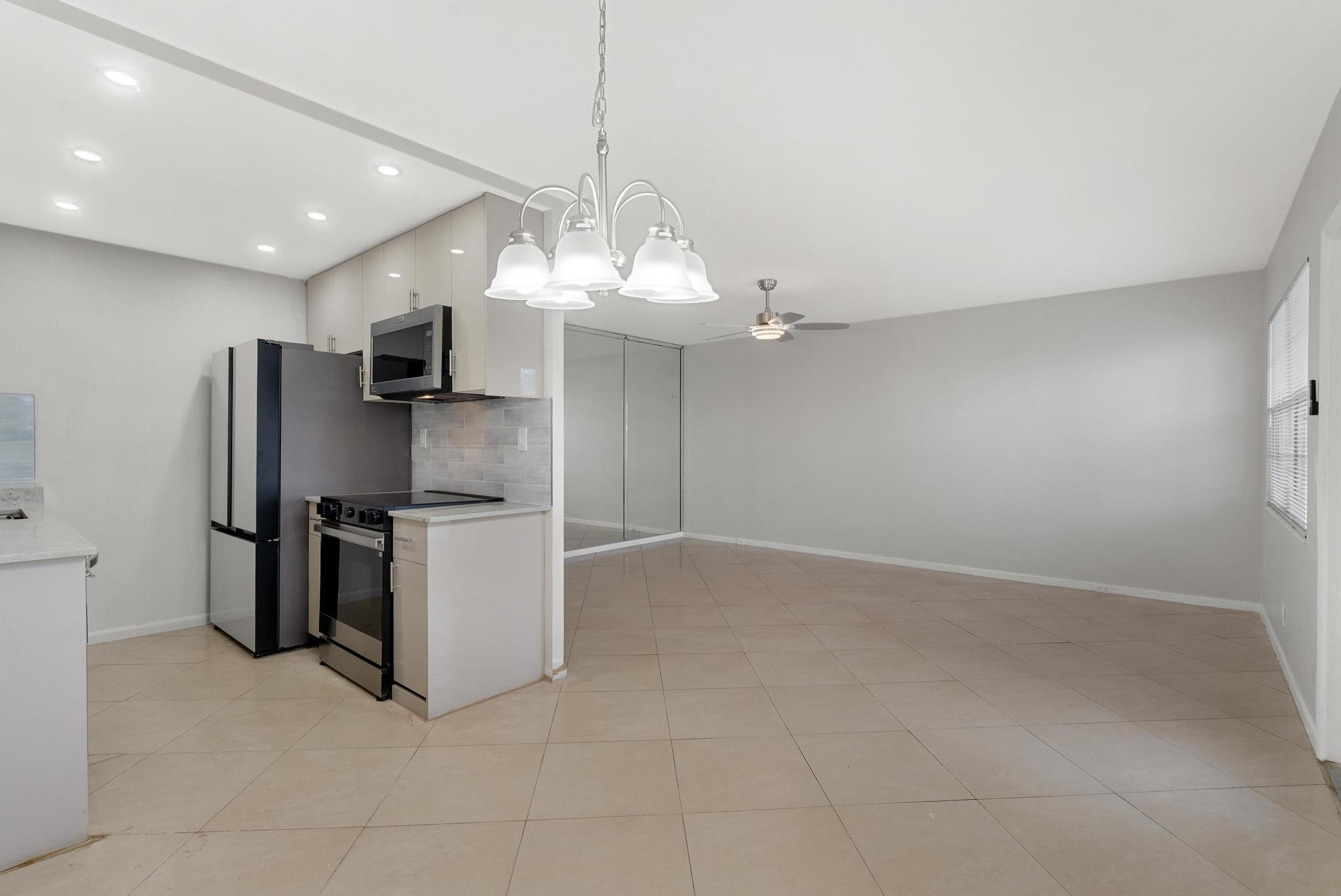 3038 Cornwall East, Unit 3038 Boca Raton, FL 33434 - Photo 6 of 32 a kitchen with stainless steel appliances a refrigerator sink and stove