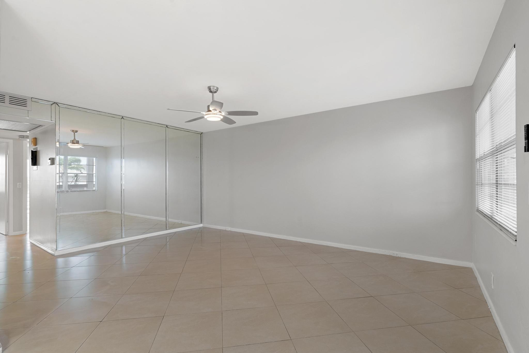3038 Cornwall East, Unit 3038 Boca Raton, FL 33434 - Photo 7 of 32 an empty room with windows and chandelier fan