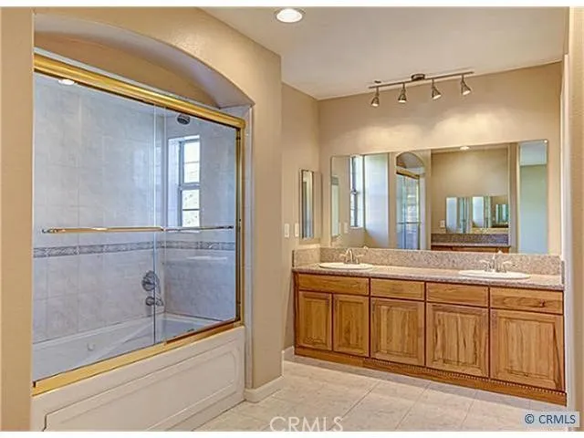 a spacious bathroom with a shower sink and mirror