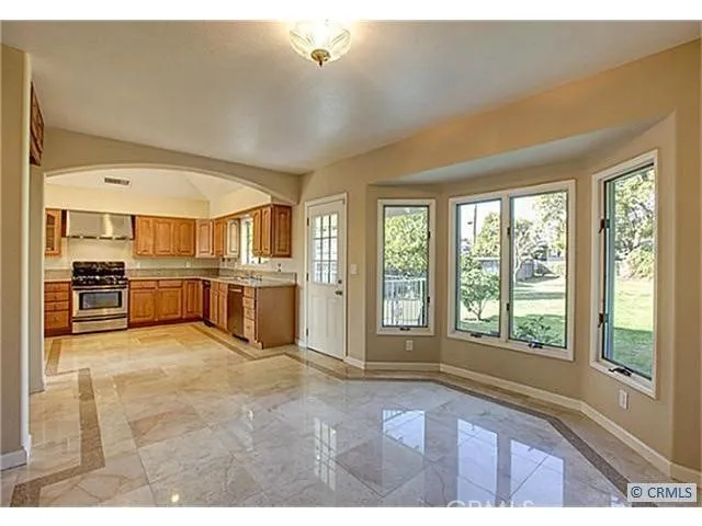 a open kitchen with stainless steel appliances granite countertop a stove and a large window